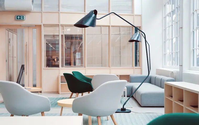 Lichte kantoorlounge met fauteuils en glaswanden